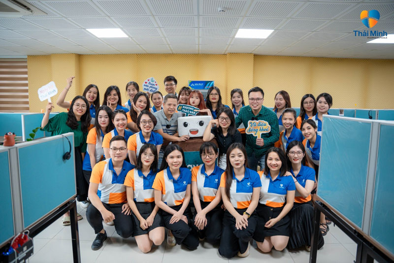 Đồng phục áo polo phối màu xanh dương và cam công ty Dược Thái Minh