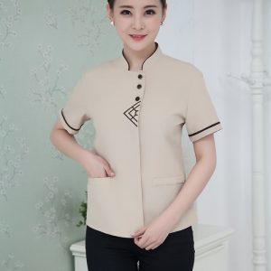 Đồng phục buồng phòng khách sạn màu be họa tiết trên ngực, cổ tàu, form Loose Fit vải kate ford
