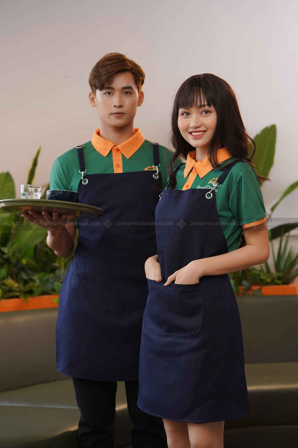 Áo đồng phục nhà hàng xanh lá cây đậm cổ cam phối tạp dề đen